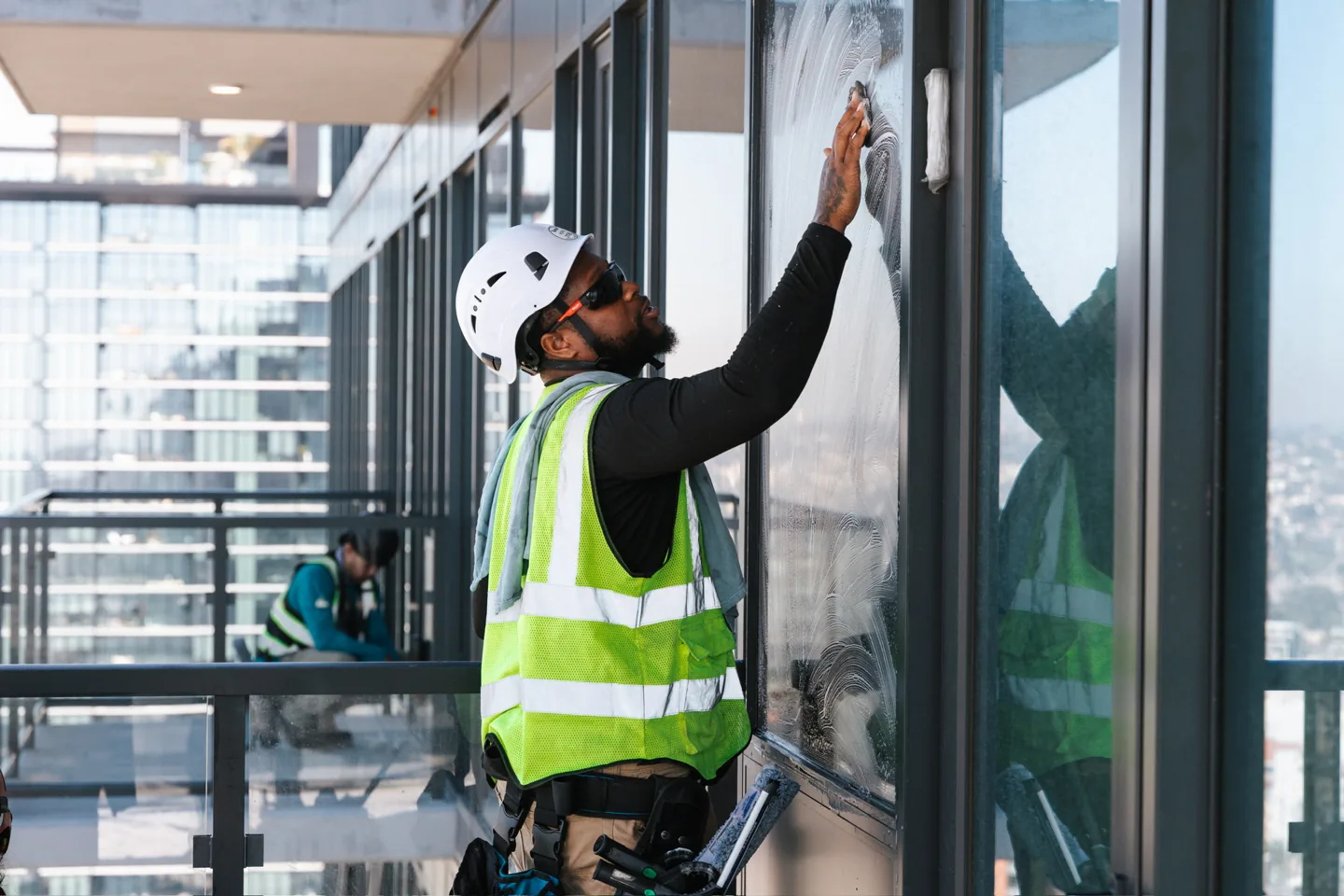 PCS crew in hard hats and safety vests detailing large glass panels