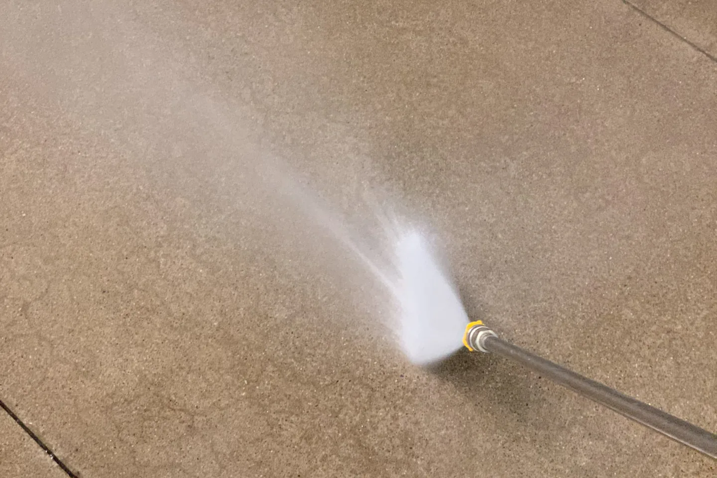 Pressure washing lifting dirt from a paved surface